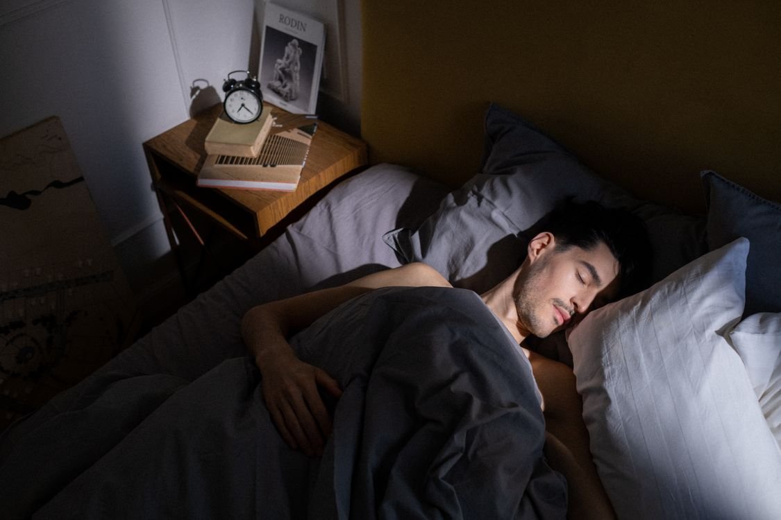 Man sleeping peacefully on his side in morning light — side sleeping is a safer alternative to mouth tape for reducing snoring